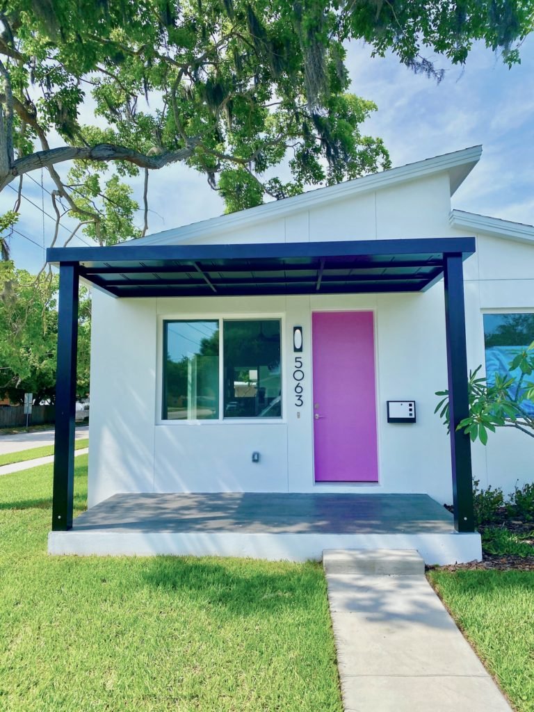 The front of the home designed for narrow lots. It is fabulous with the pink door.