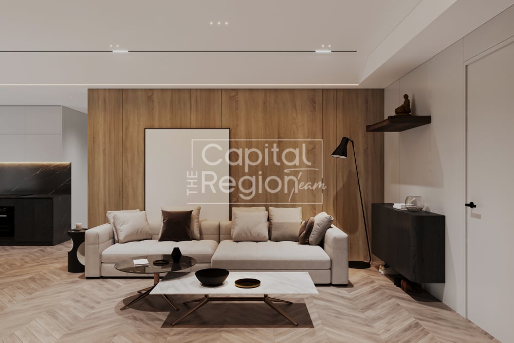 Modern living room with a cream sectional, wood-paneled wall, and herringbone flooring.