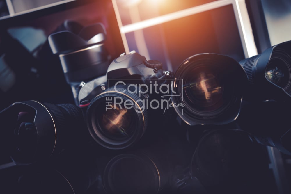 Several cameras and lenses arranged together, with Capital Region Team branding overlaid.