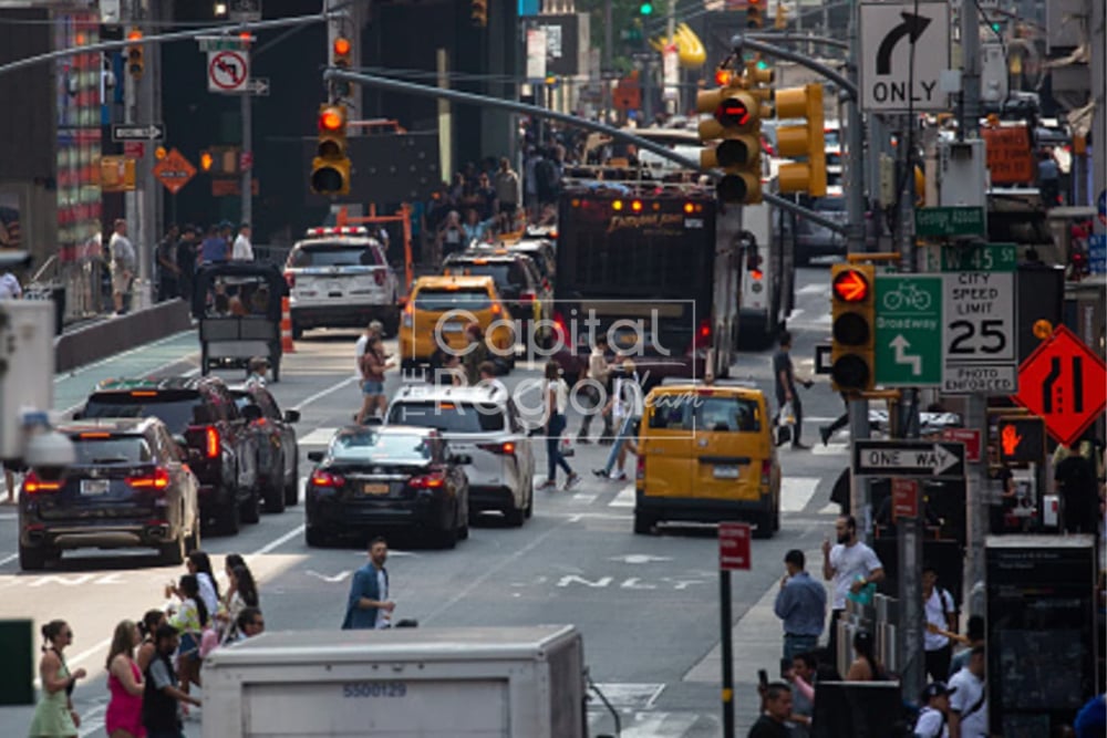Busy Manhattan street near West 45th Street, with yellow taxis and pedestrians crossing.
