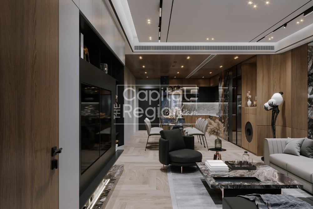 Modern luxury living room with a black media wall, warm wood paneling, and marble coffee tables.