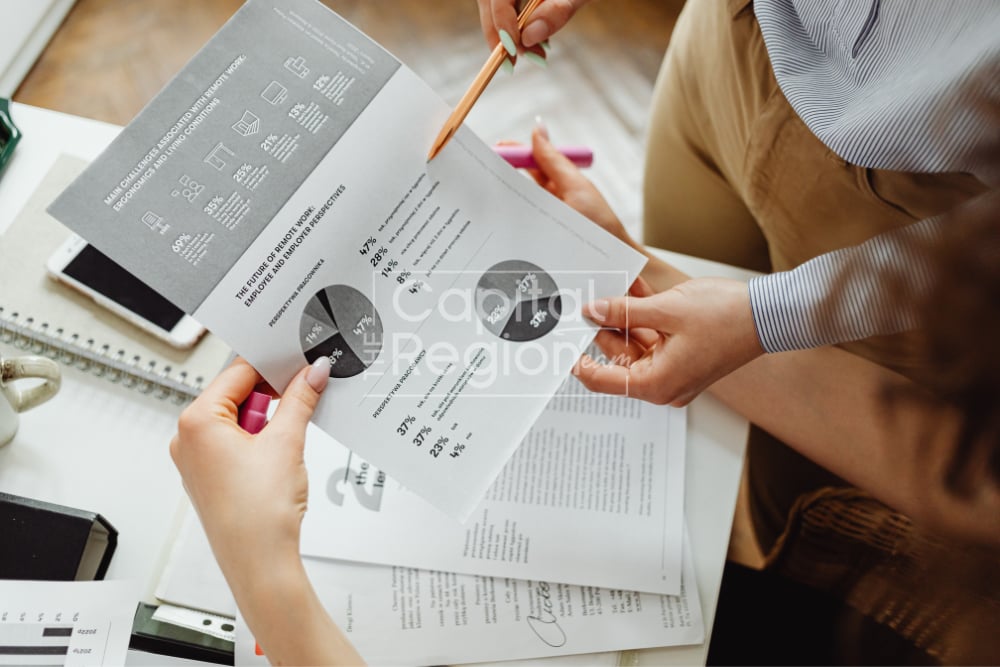 People review printed charts together as one points to a report.