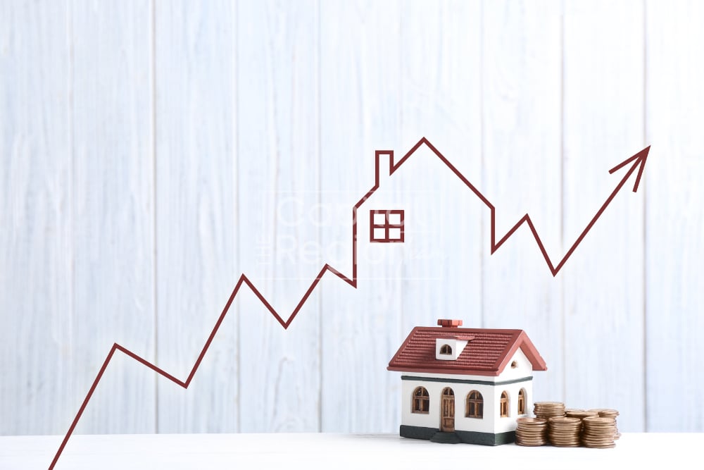 Miniature house and stacks of coins beneath a rising arrow graph.