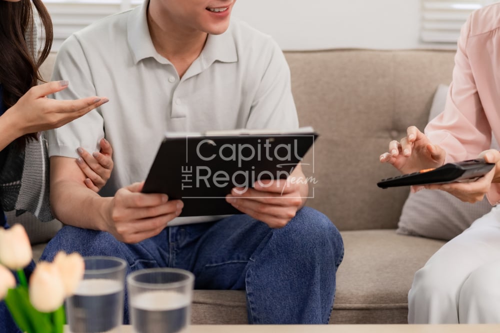 Adults discuss information on tablets while seated together on a living-room sofa.