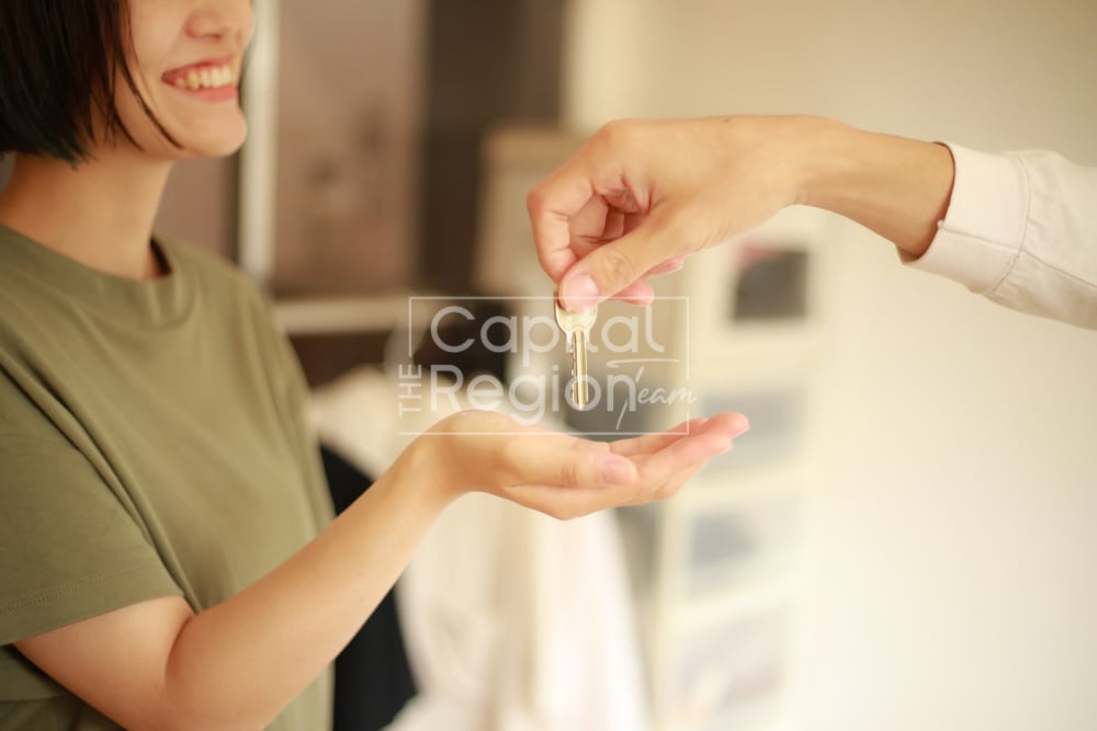 A woman receives a house key from another person.