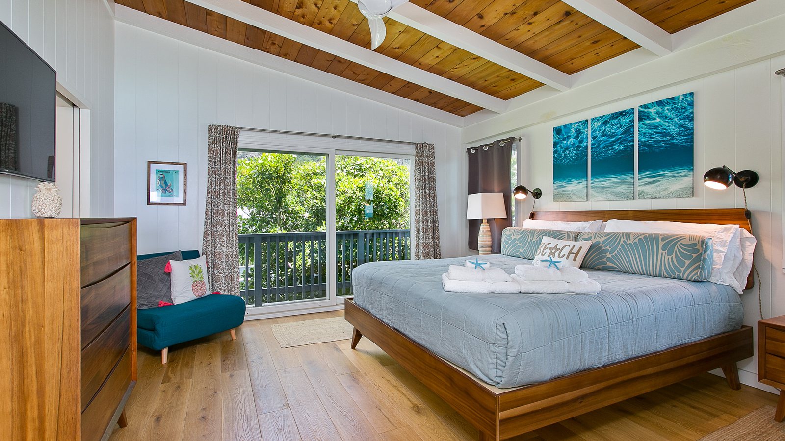 Bright bedroom with a wood ceiling and sliding doors to a lanai