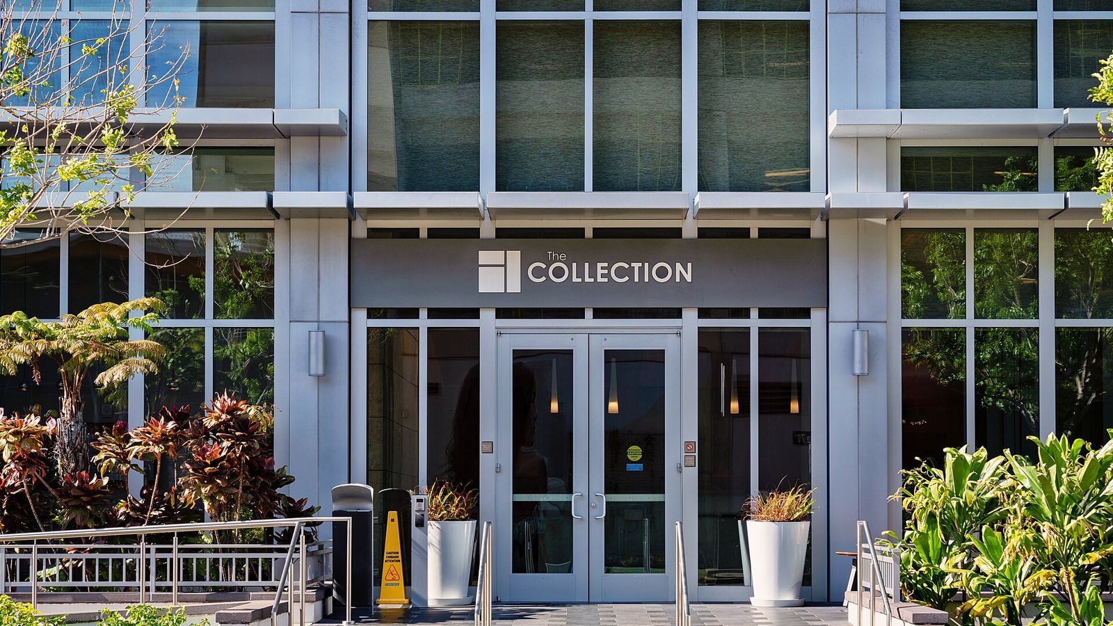 Glass entrance and landscaped lobby of a Honolulu condominium tower