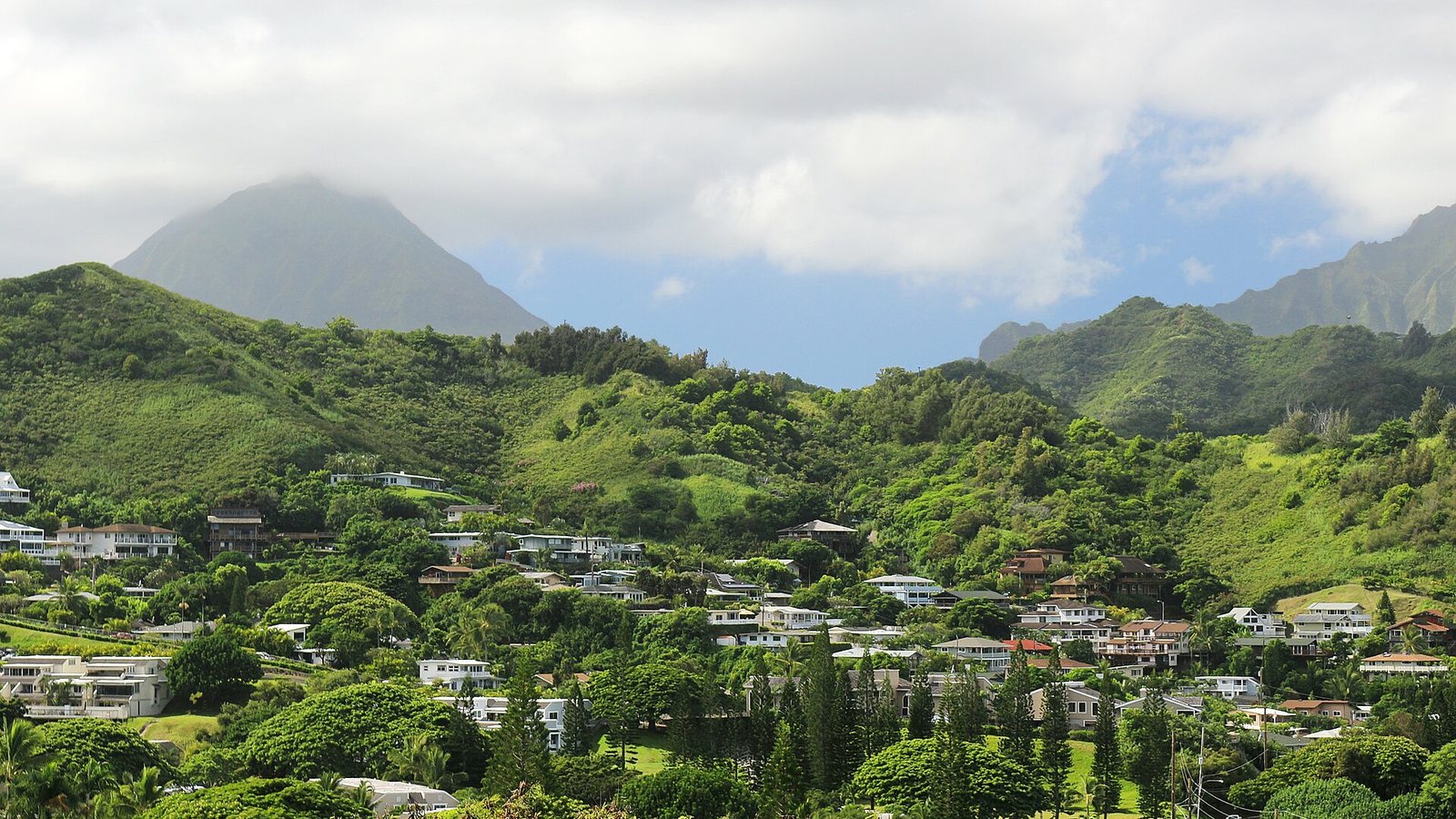 Homes spread across the hillside below Kokokahi Ridge in Kaneohe under a cloudy sky