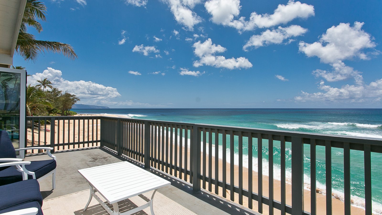 Lanai looking over a lawn to the beach and ocean on the North Shore