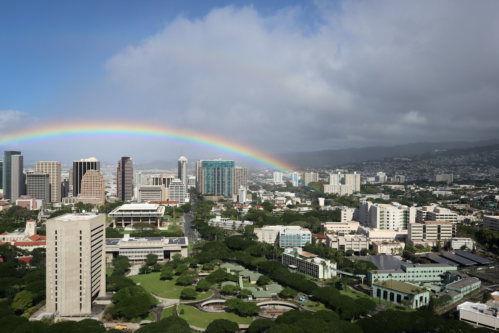 Rainbow over Honolulu high-rises and the Ala Wai area on a partly cloudy day