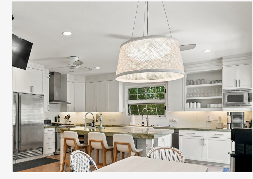 The remodeled kitchen at 245 Palaoa Place, with its oversized island, custom lighting, and views out to the garden