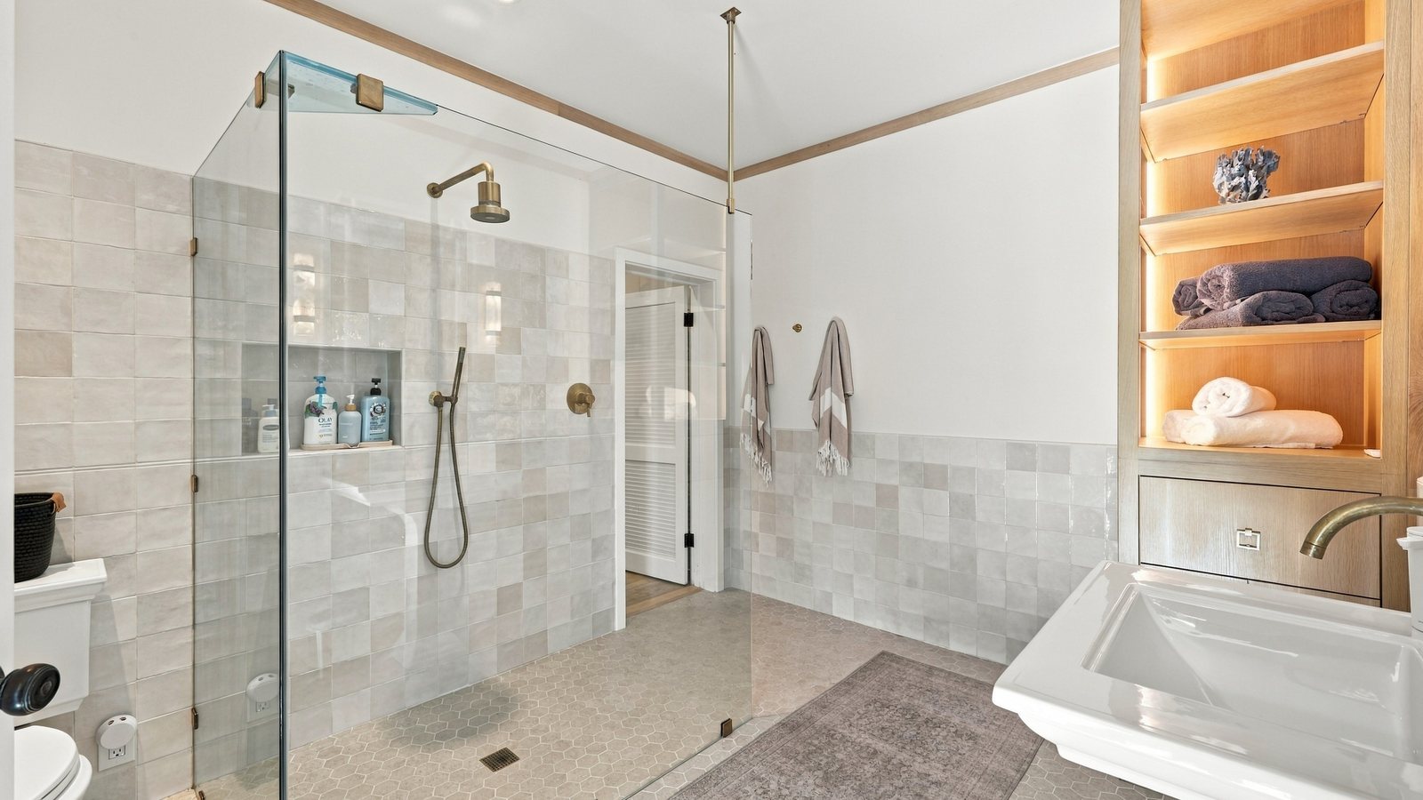 Remodeled bathroom with a glass walk-in shower and white tile