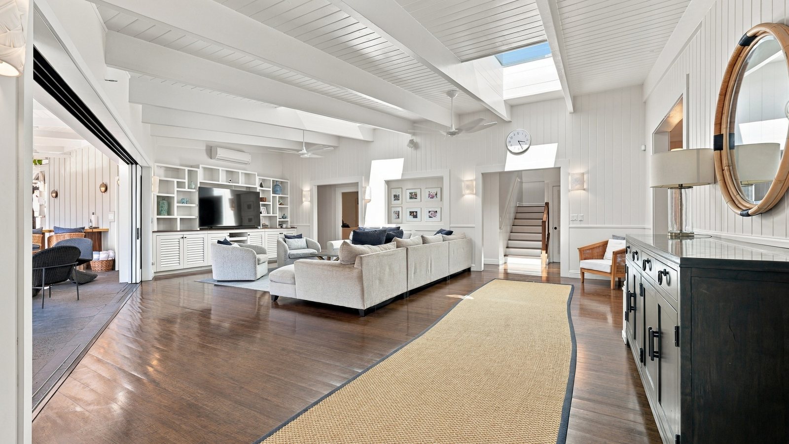 Open-plan living area with a wood-burning stove and sliding doors in a remodeled Honolulu home