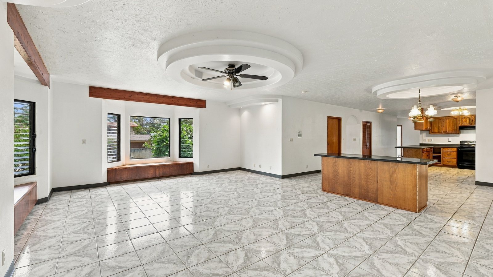 Empty, freshly updated living and kitchen area with patterned tile floors, ready for a new owner