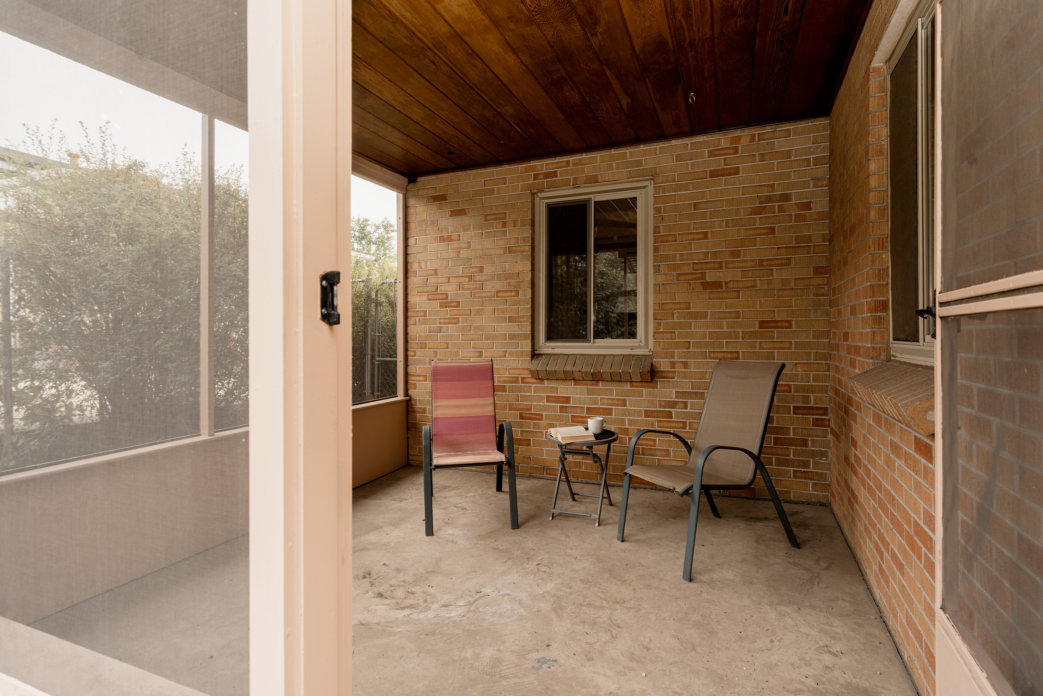 Private screened-in patio with seating at 2635 Wolff Street