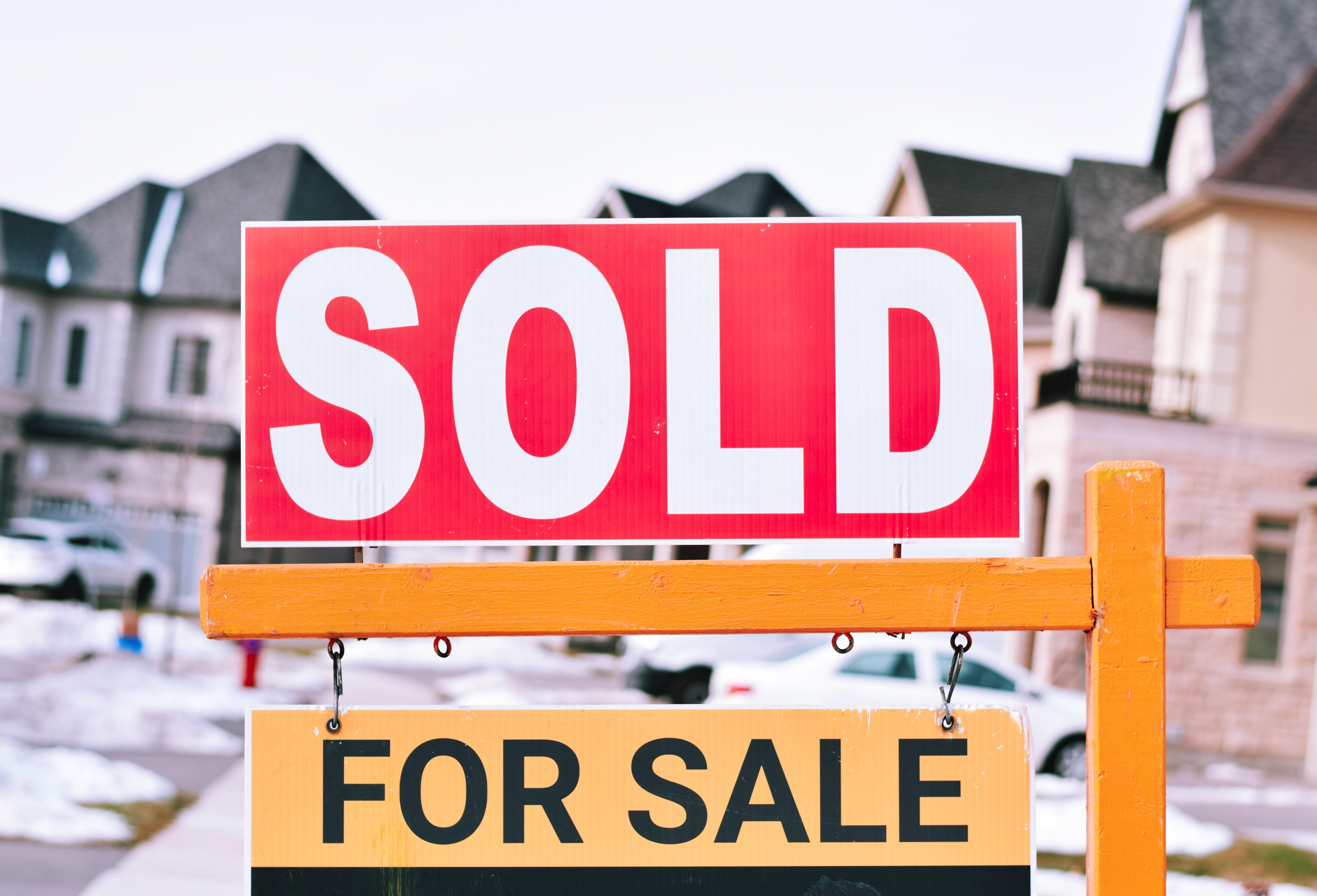 Sold sign in front of luxury homes