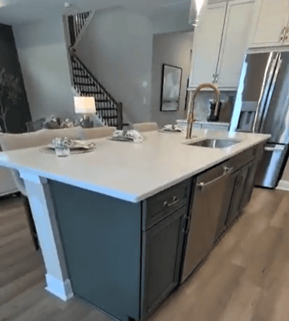 kitchen island with a sink in a william ryan home at two rivers in zephyrhills, fl