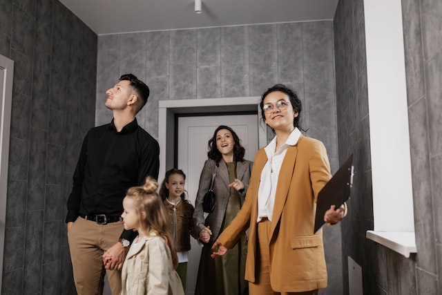 Real estate agent showing a house to a couple with a small child