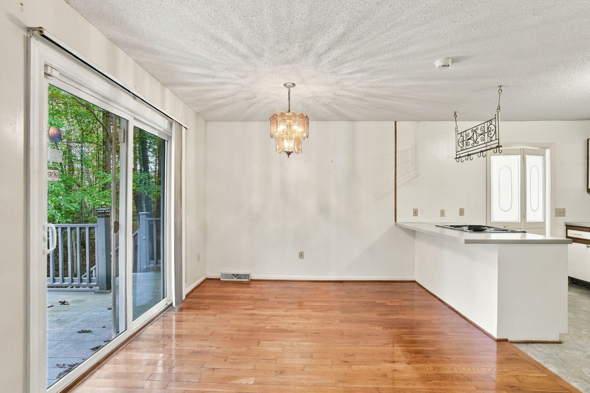 Unstaged dining area with sliding glass doors and adjoining kitchen counter