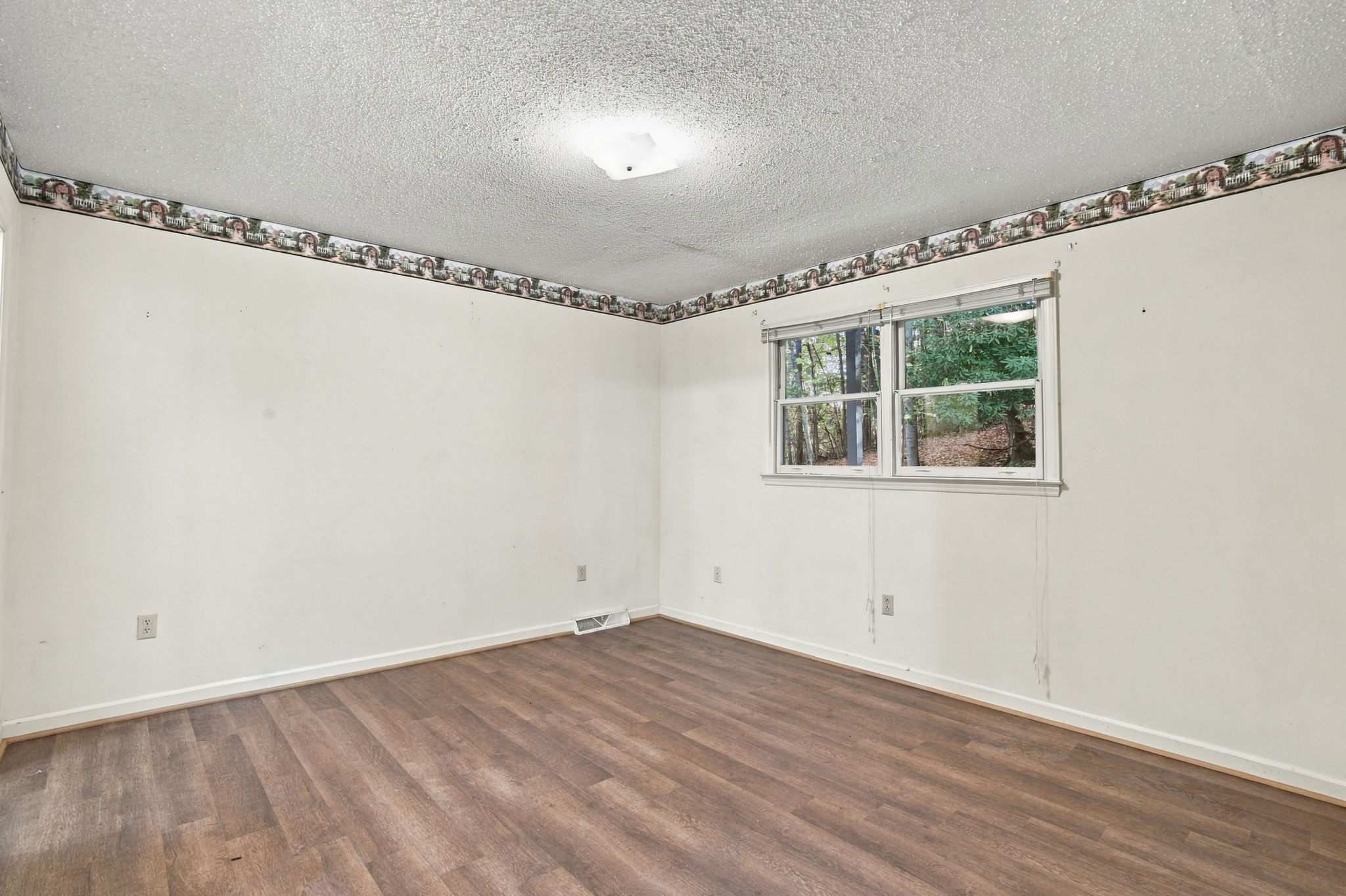 Actual bedroom with white walls and hardwood floors