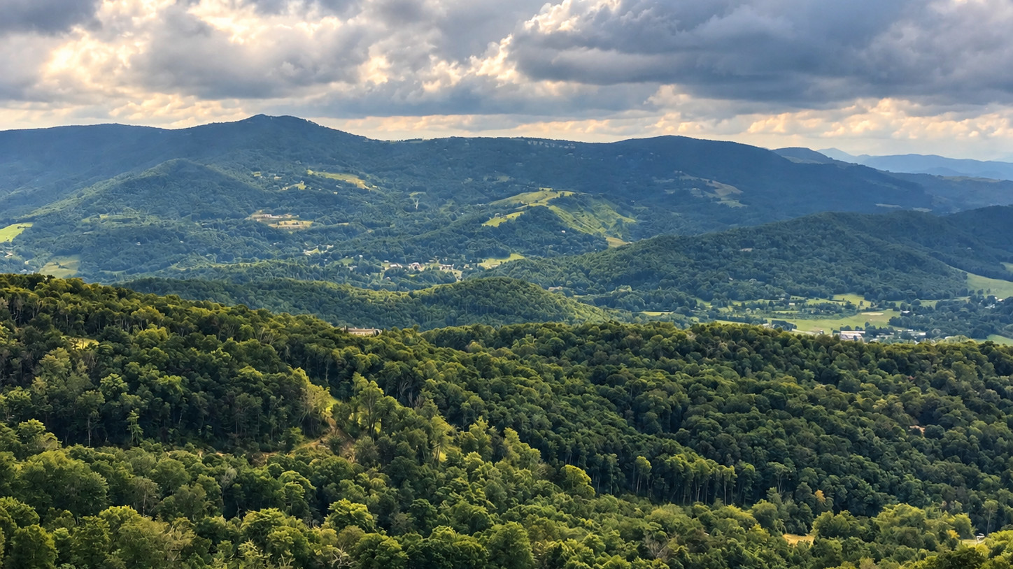 Layered Blue Ridge mountain views from Sugar Mountain beneath dramatic clouds