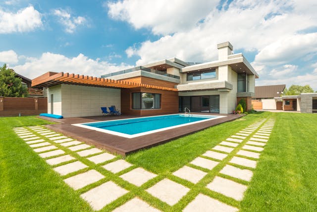 Modern vacation home with a pool and landscaped yard featuring a minimalist design
