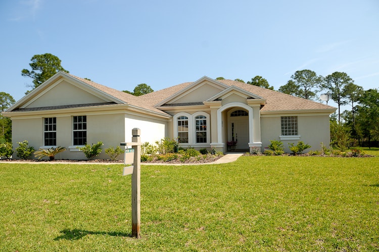 House with a FOR SALE sign on the lawn