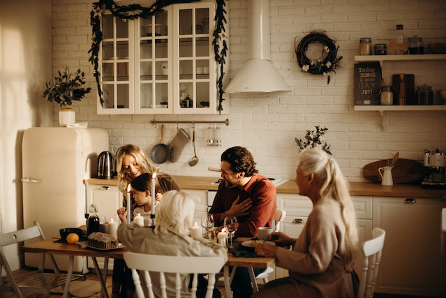 family sits and laughs in the kitchen