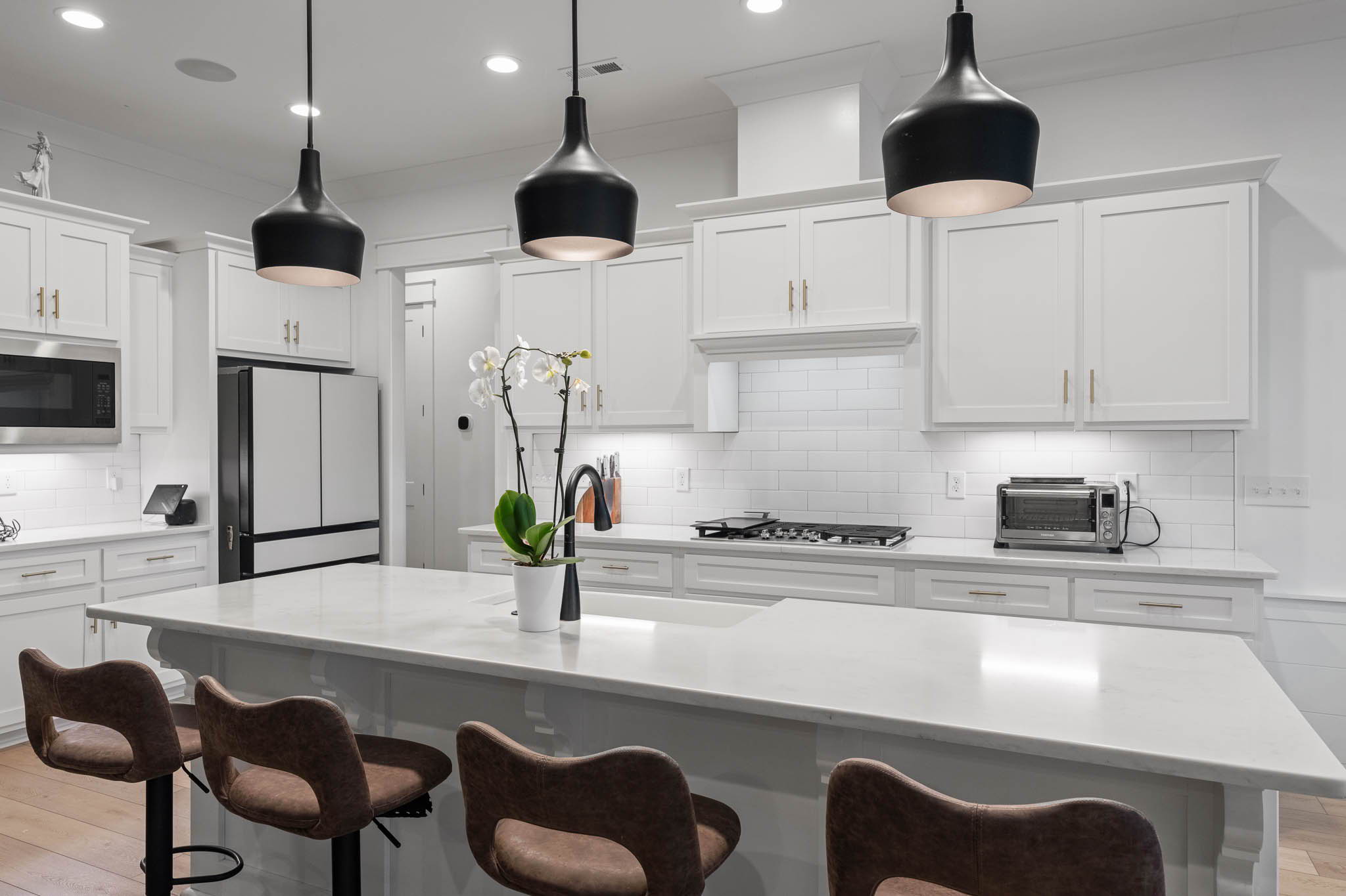 The kitchen features quartz countertops, custom cabinetry, a 36 gas cooktop, and double ovens.