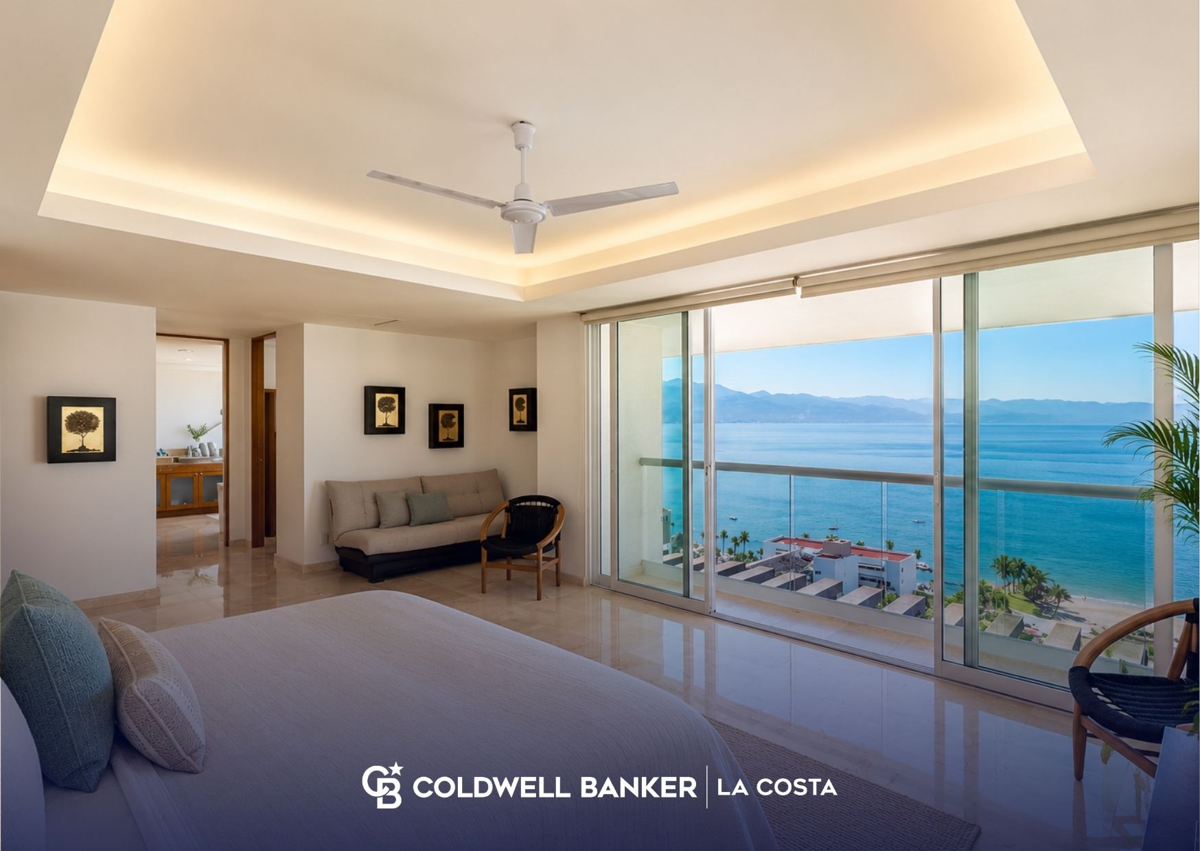 Una pareja revisando planos de una propiedad en una terraza con vista a la Bahia de Banderas mientras decide entre una segunda casa y una propiedad de inversión