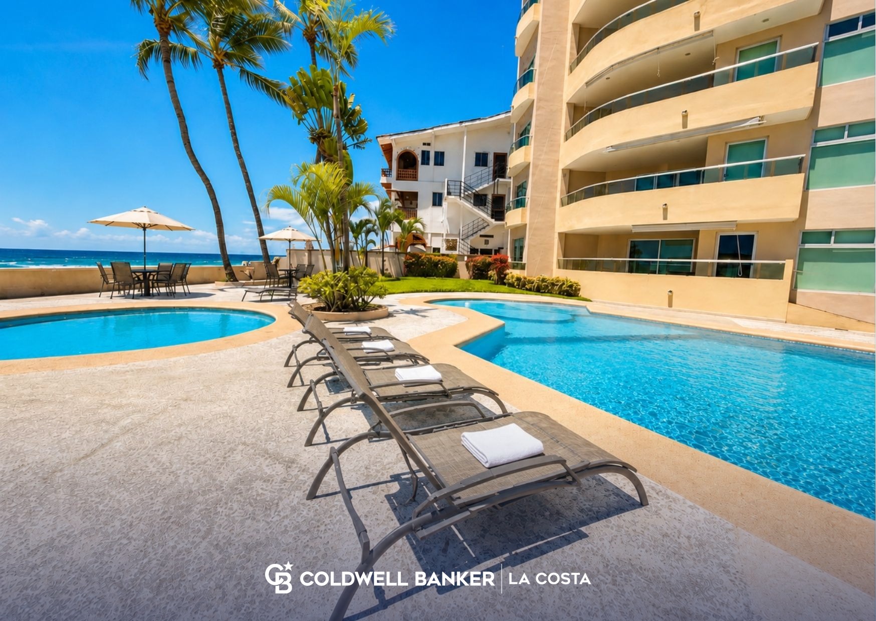 Terraza con alberca y camastros junto a un edificio de condominios frente al mar en Puerto Vallarta, un entorno t&iacute;pico de renta vacacional