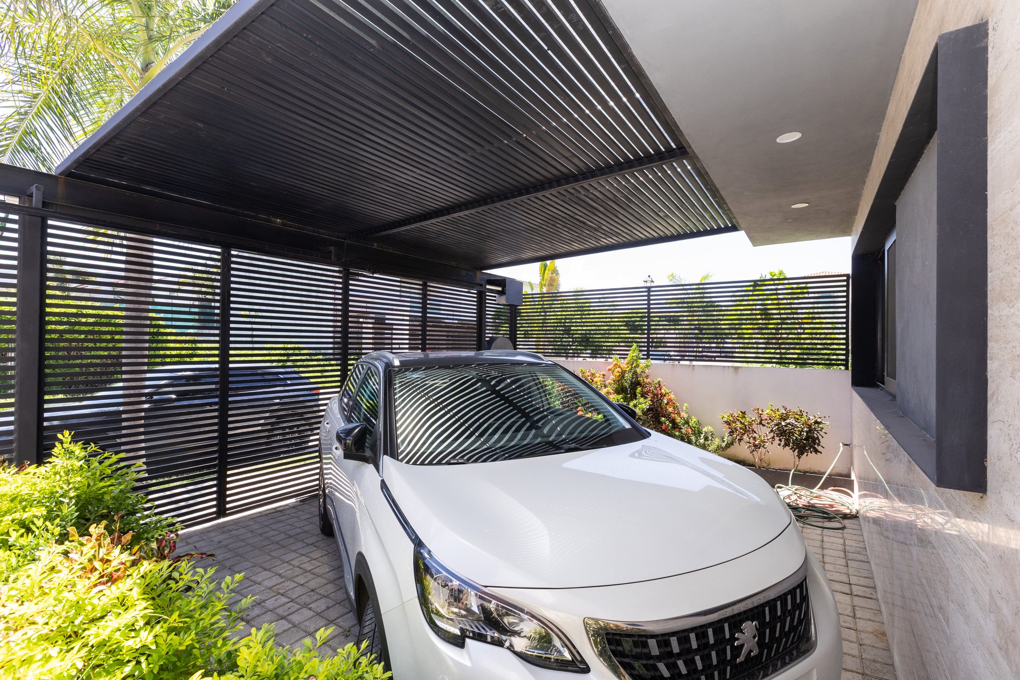 Covered parking under a louvered roof inside the gate