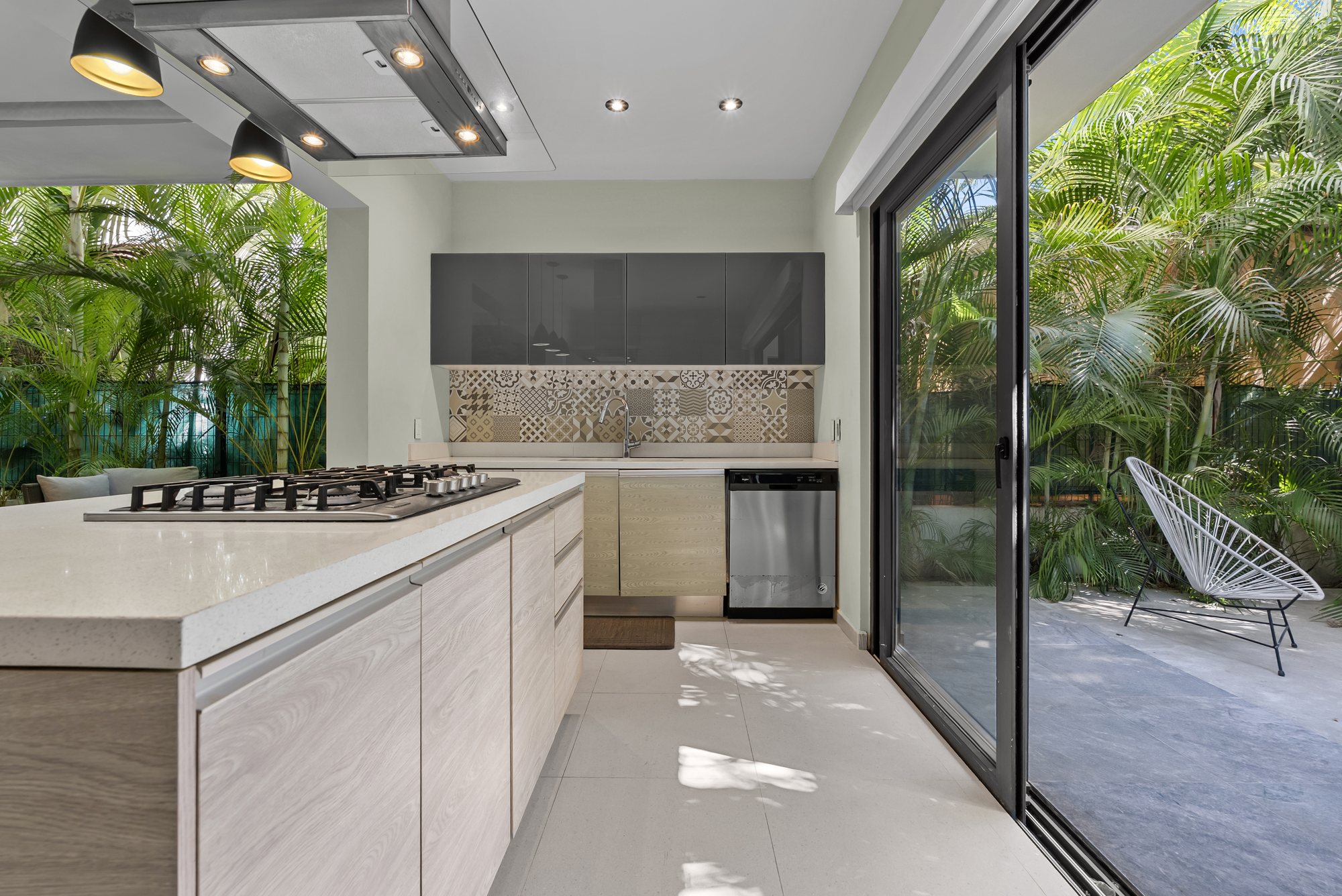 Cocina con puertas corredizas de cristal abiertas hacia el patio trasero
