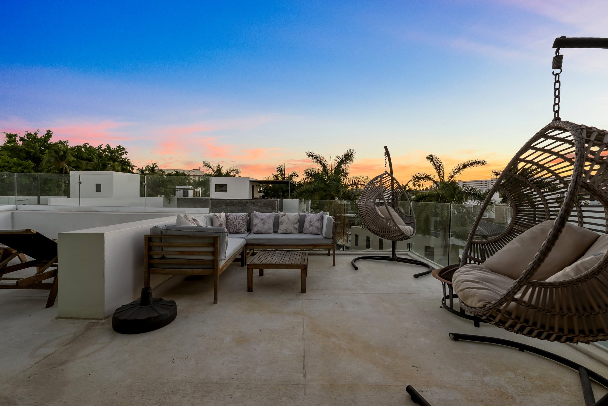 Roof top al atardecer con sala exterior y silla colgante