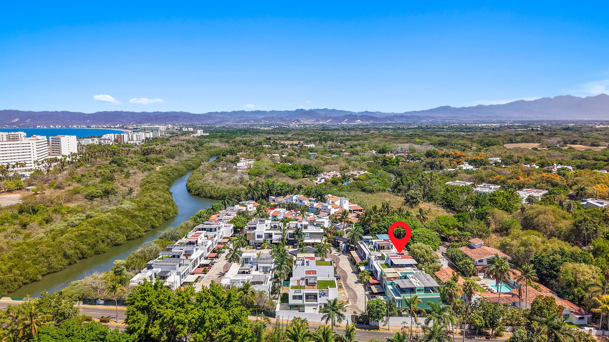 Vista aérea de la comunidad junto al río, con un marcador sobre la casa