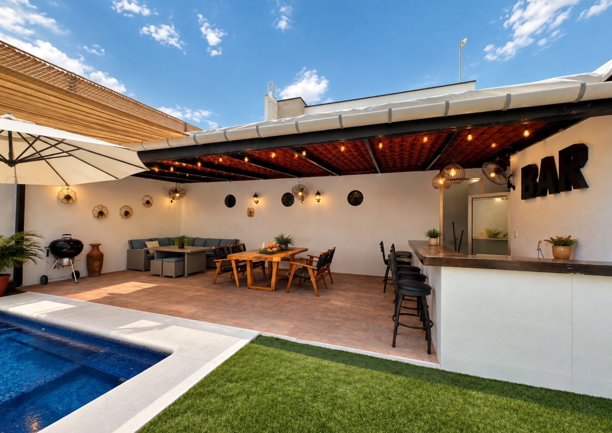 Terraza techada con teja, barra, asador y comedor exterior junto a la alberca