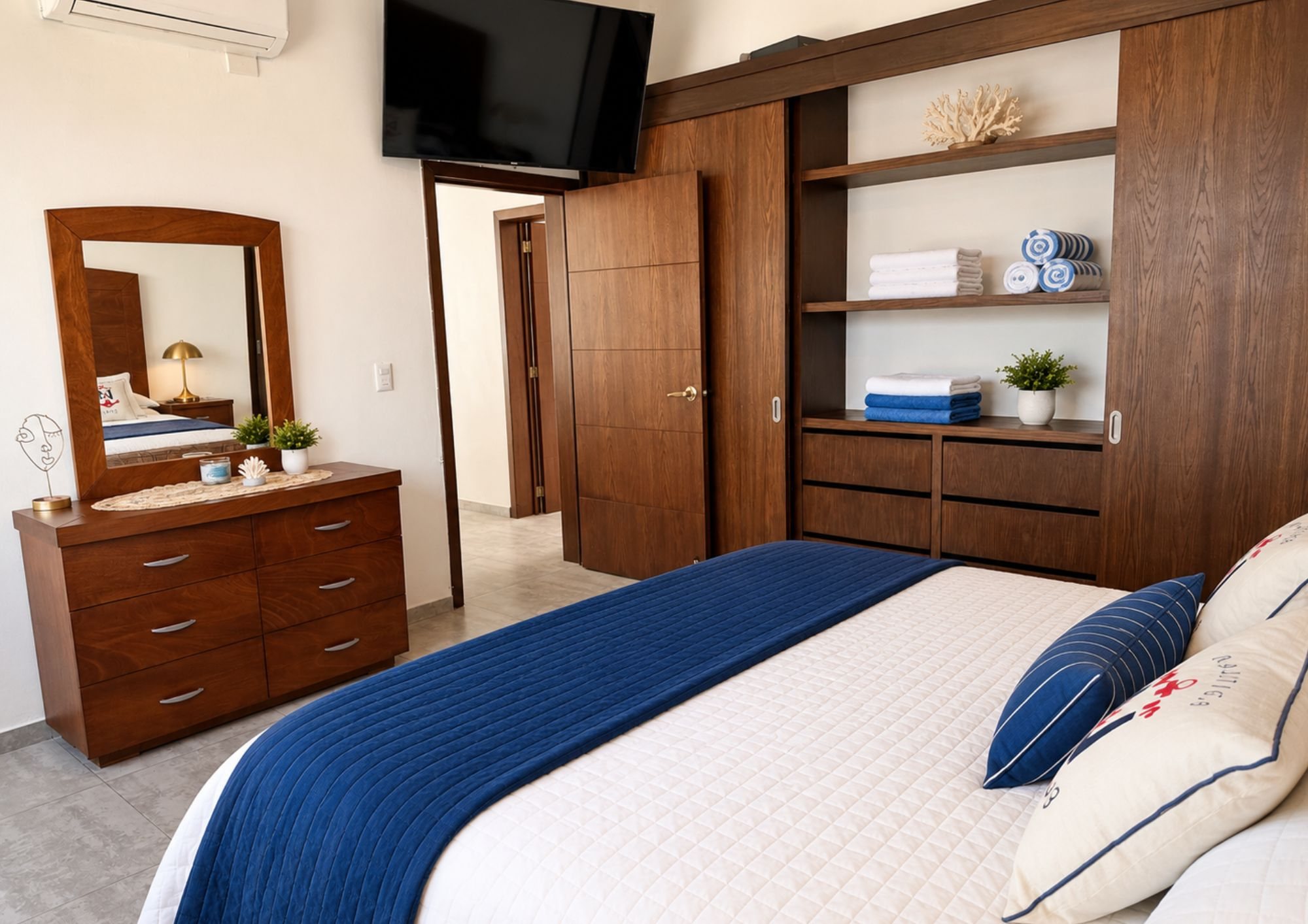 Recámara con clósets de madera empotrados, cómoda y TV