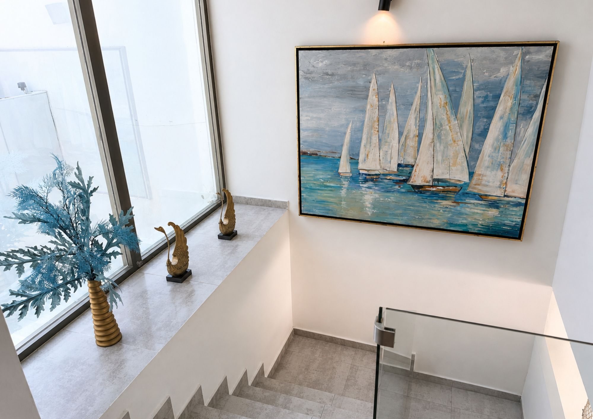 Escalera con barandal de cristal y ventanal alto