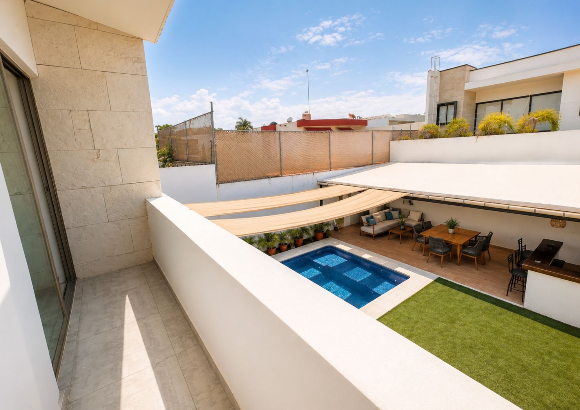 Balcón con vista hacia la alberca, el jardín y la terraza techada