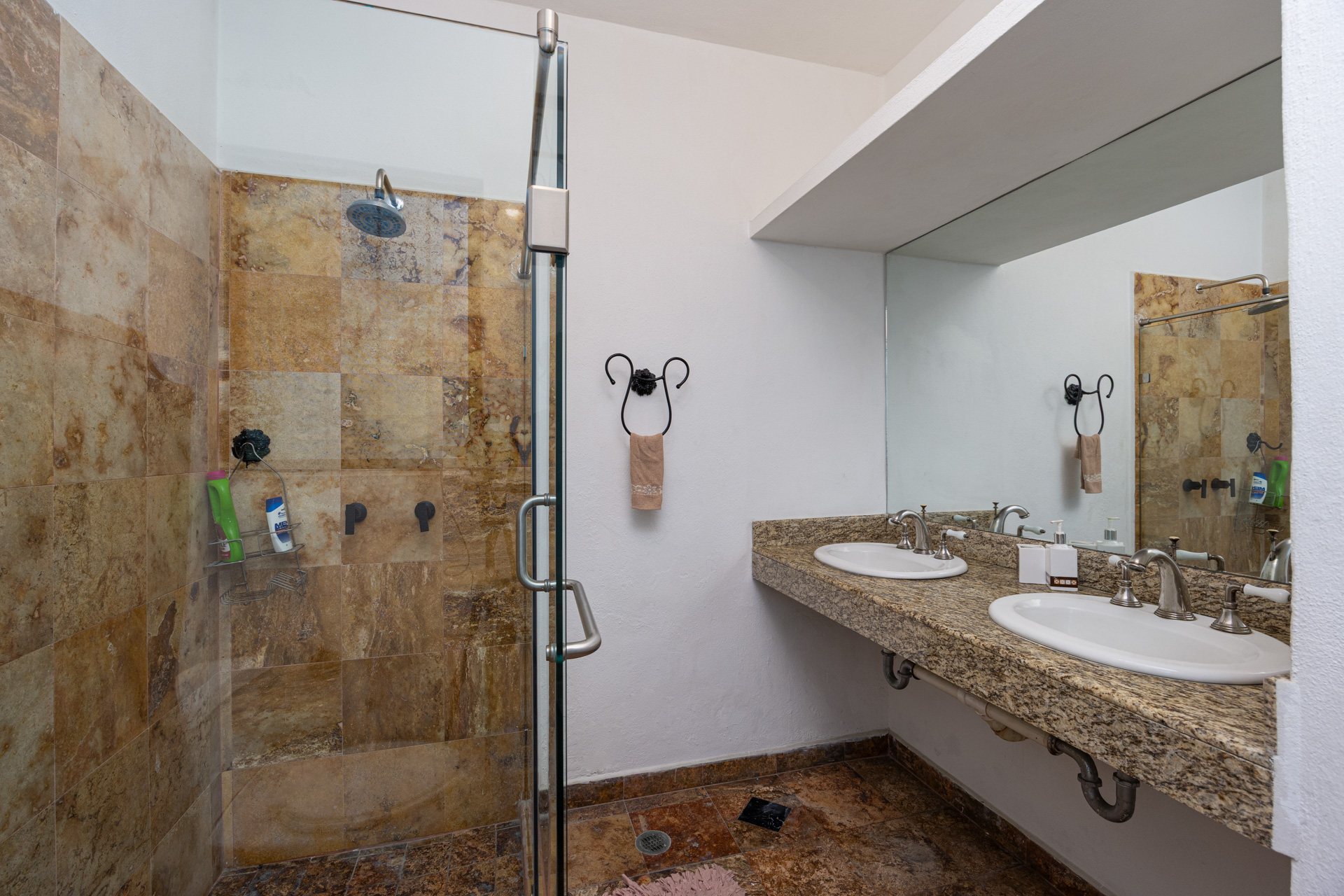 Baño con regadera de piedra y doble lavabo