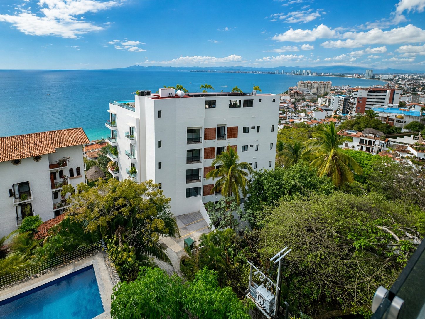 El edificio en la ladera de Amapas sobre la bahía, con una alberca abajo