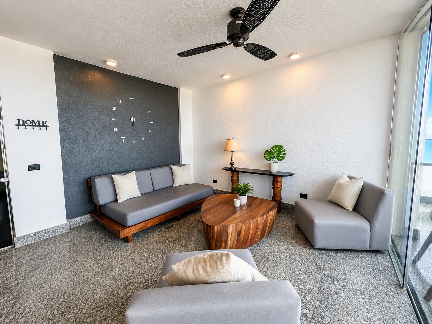 Sala con sofá gris, mesa de centro de madera y reloj de pared