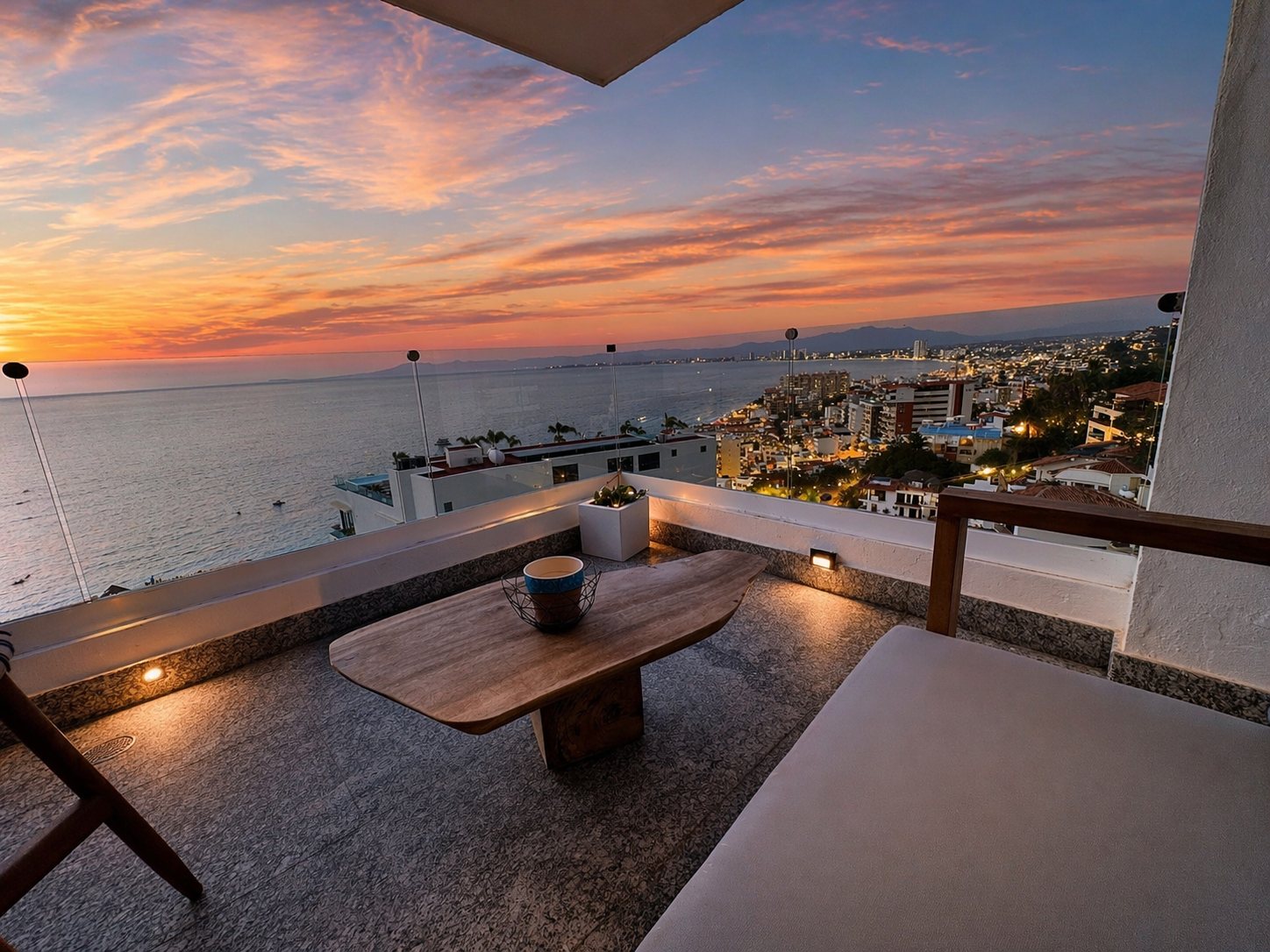 Sala de terraza al anochecer sobre la bahía y las luces de la ciudad