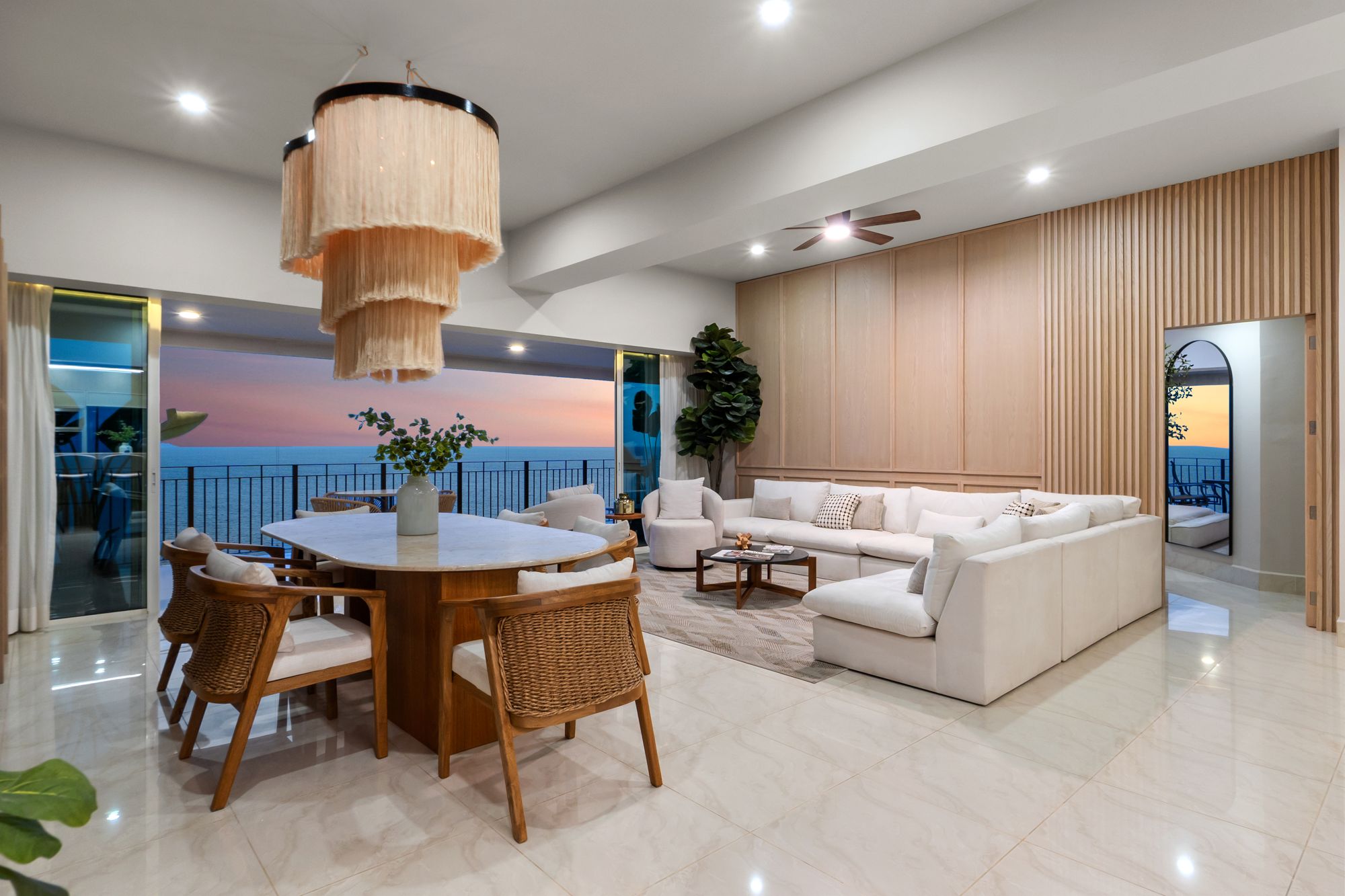 Living and dining room at dusk with the bay through the glass doors