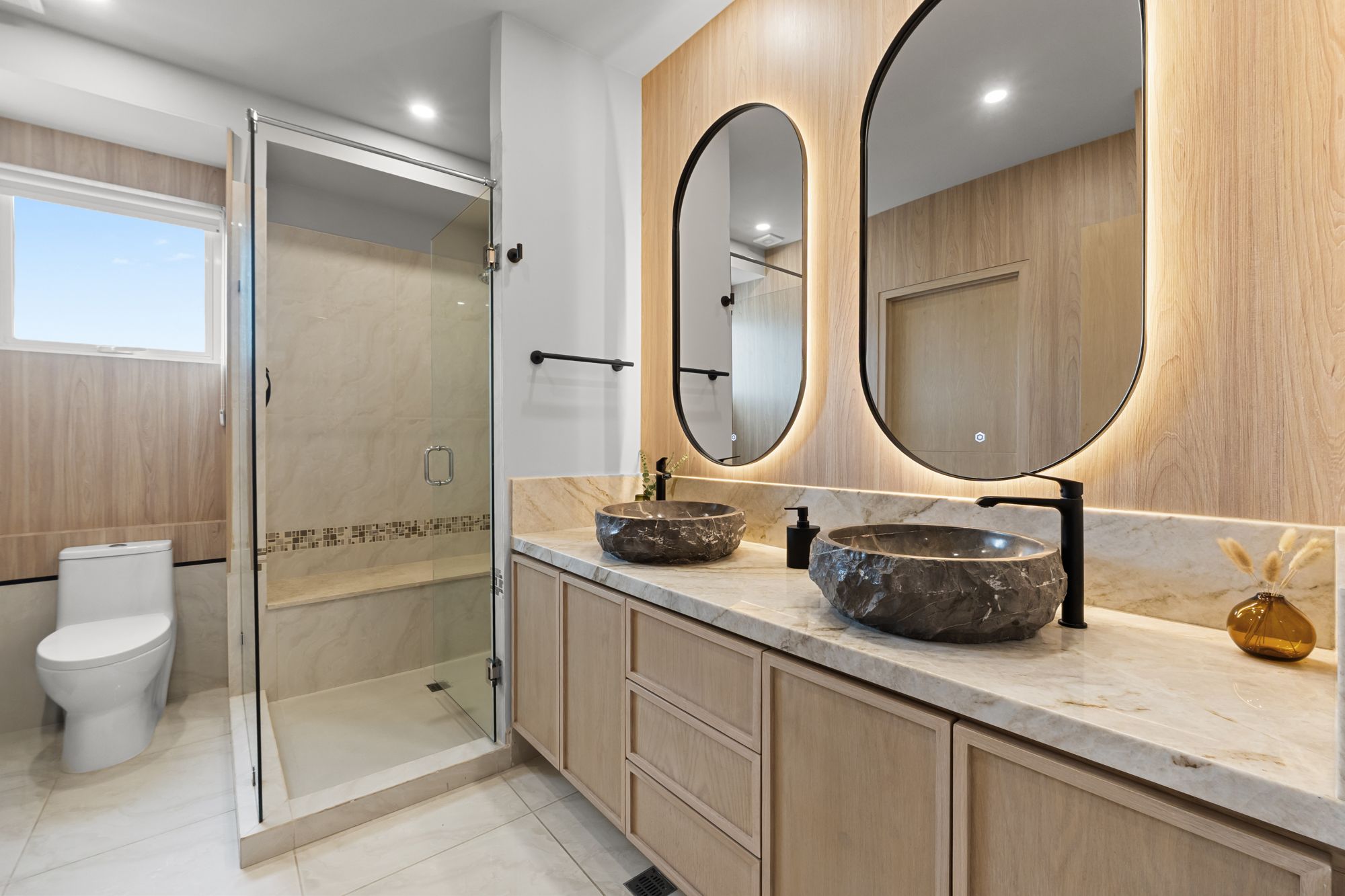 Primary bathroom with double stone vessel sinks and a glass shower