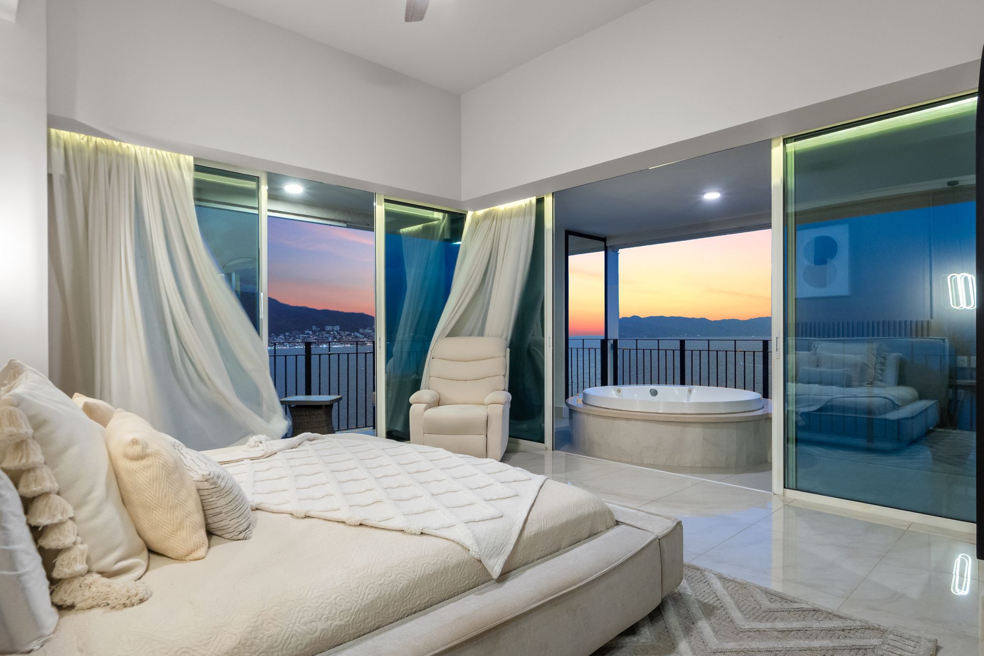 Primary suite at dusk with the terrace jacuzzi lit