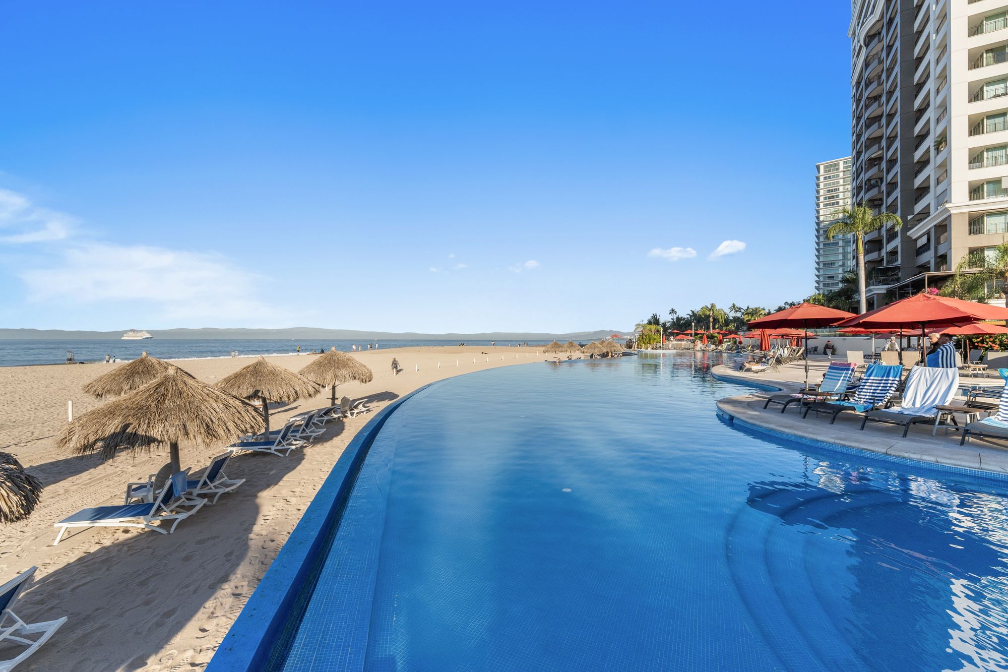 Grand Venetian infinity pool at the edge of the beach