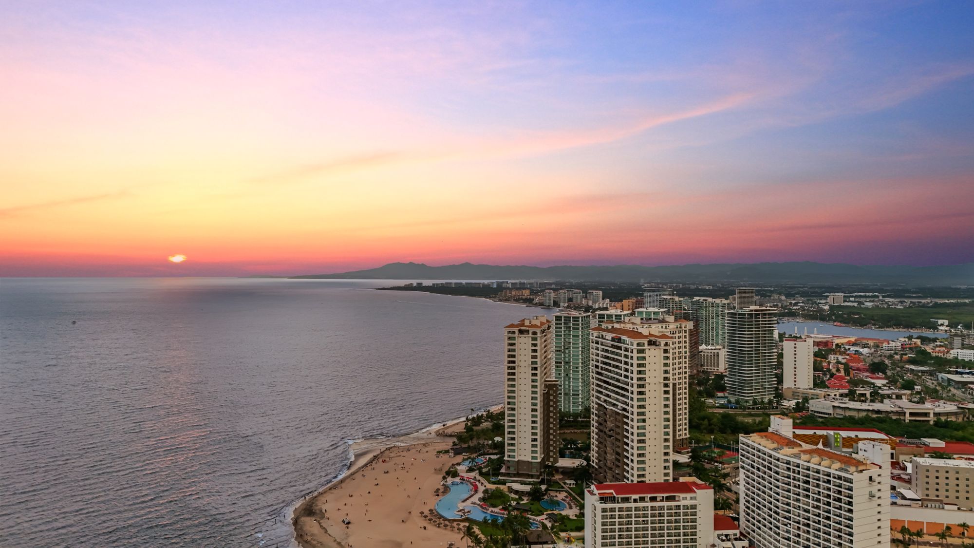 Aerial view of the Puerto Vallarta Hotel Zone and Banderas Bay at sunset
