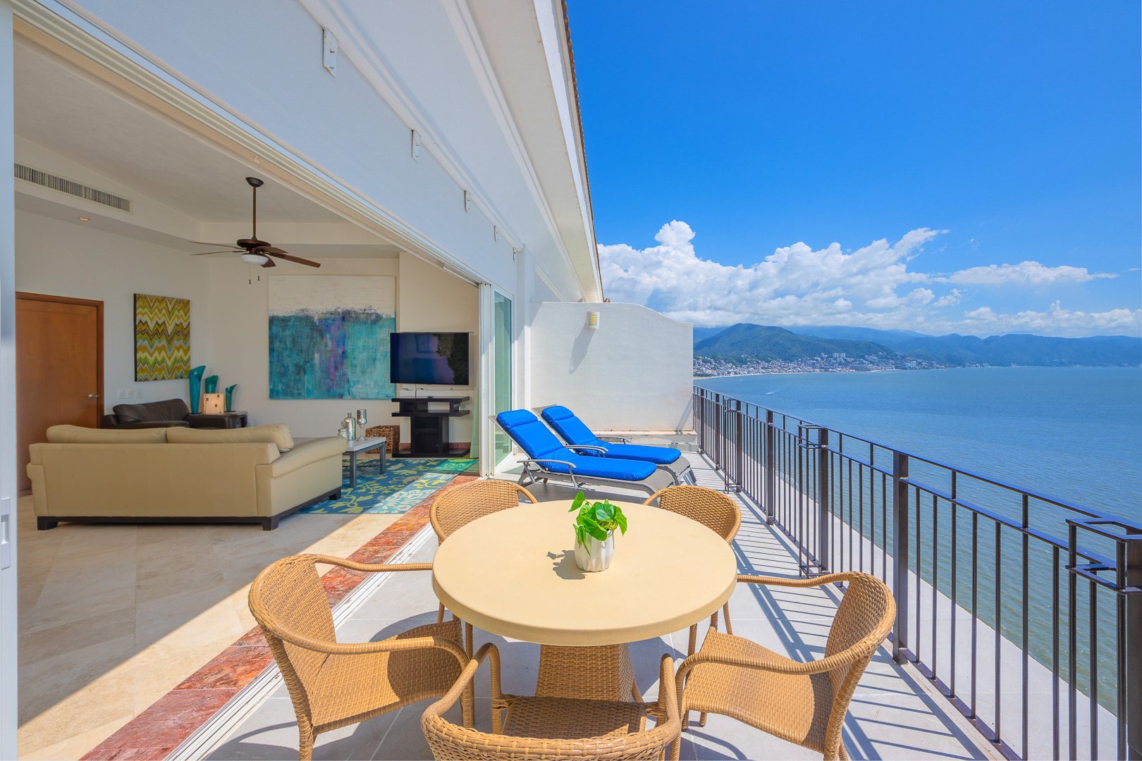 Private terrace off the upper floor, with loungers and a view across the bay