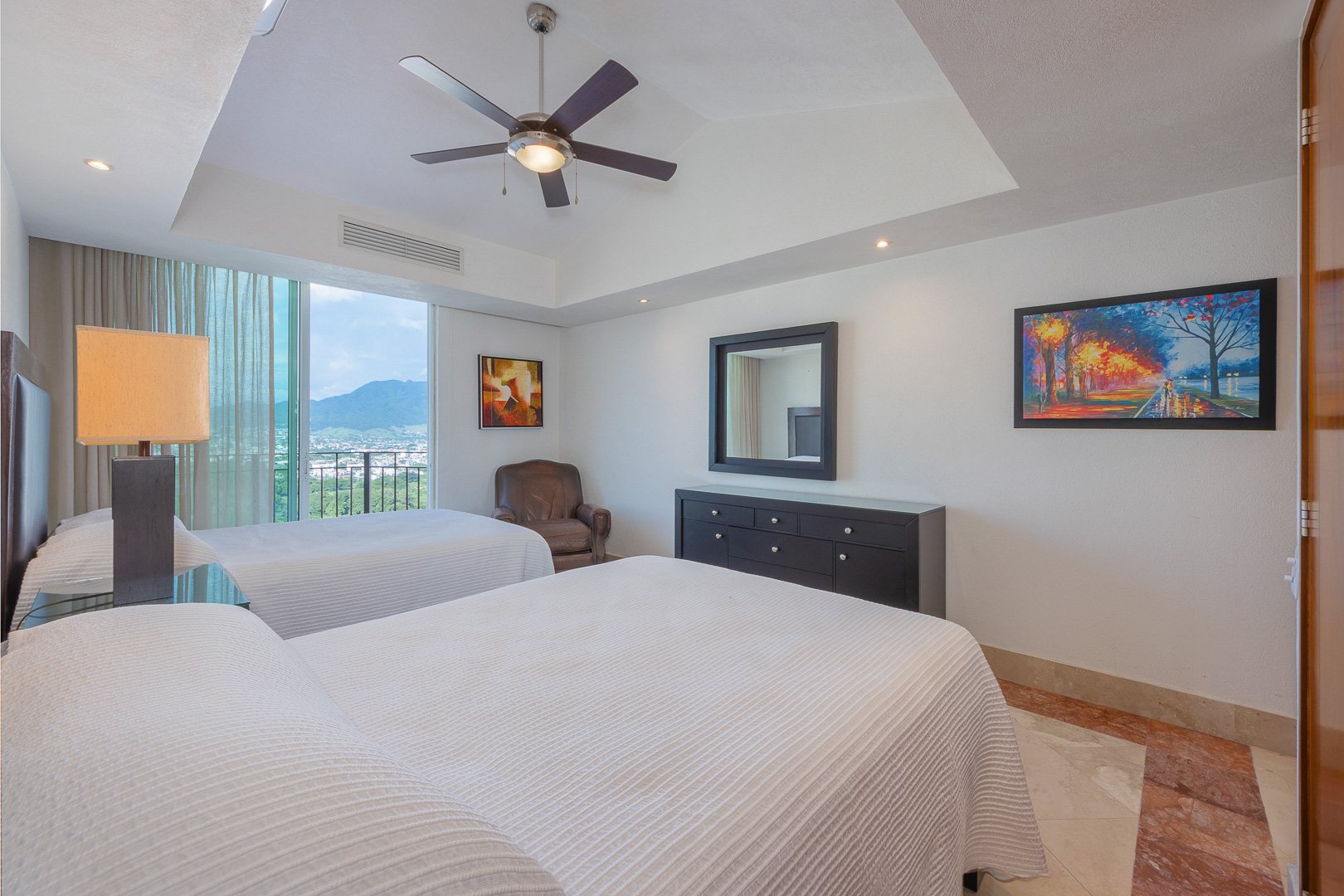 Bedroom with two beds and a city and mountain view